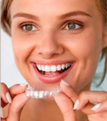 Paciente segurando alinhador invisível Invisalign